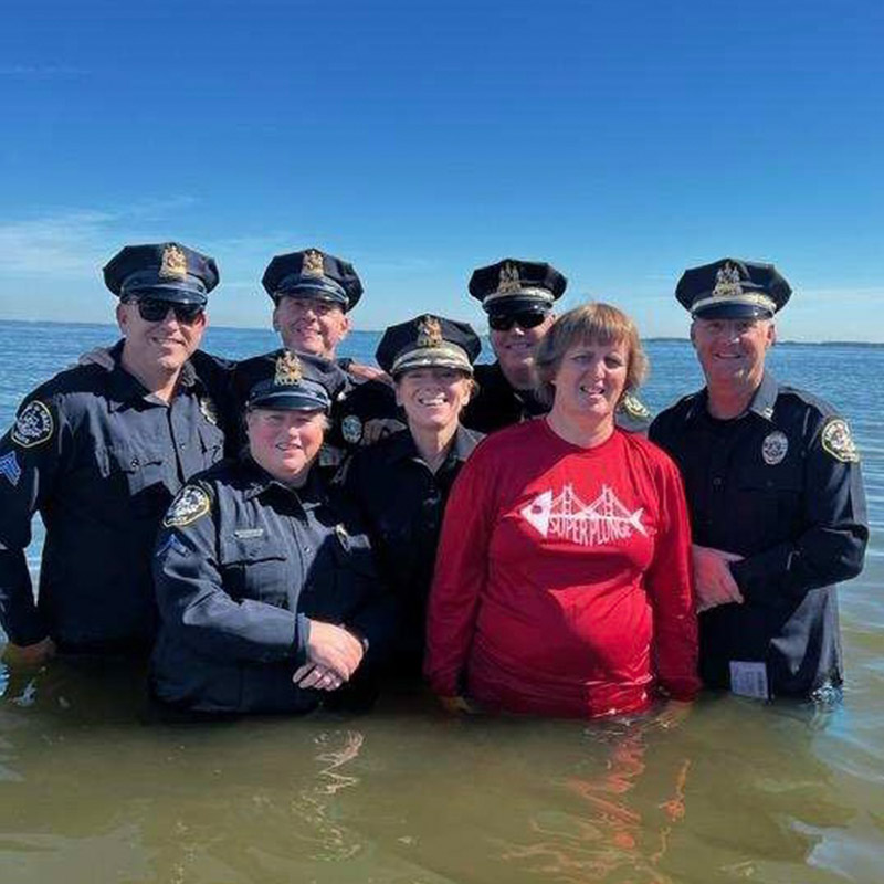 chief and officers with special olympics athlete in the cold water